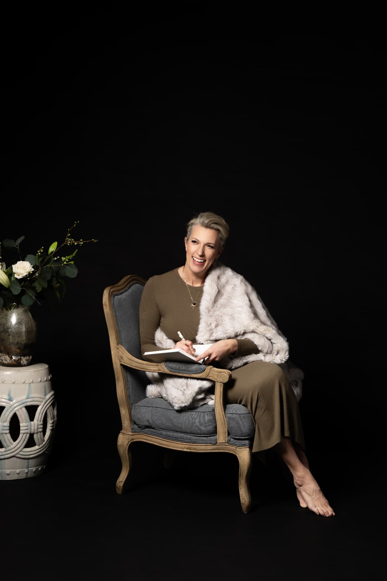 Carrie seated in her studio, notebook in hand