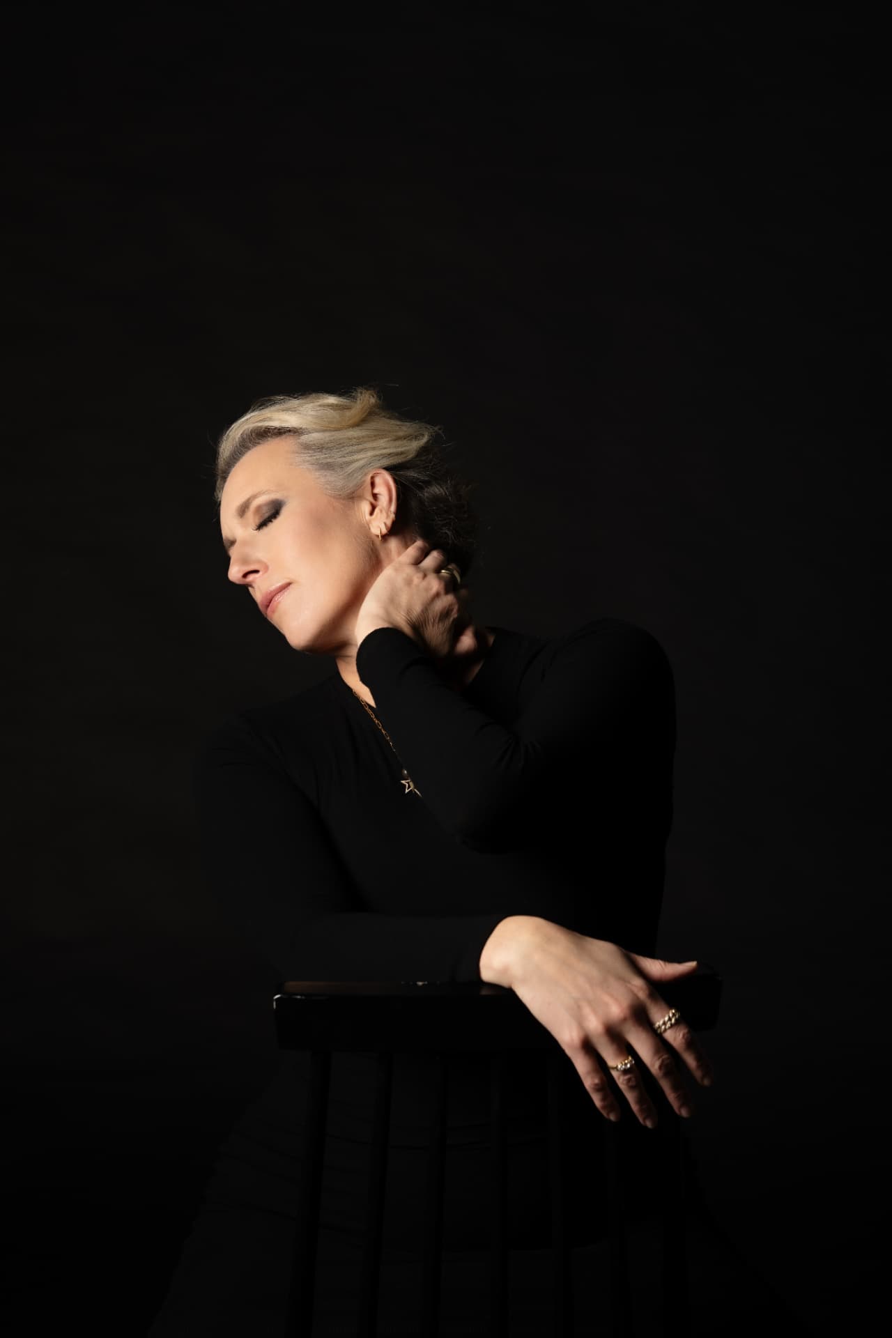 Carrie in profile, eyes closed, against black
